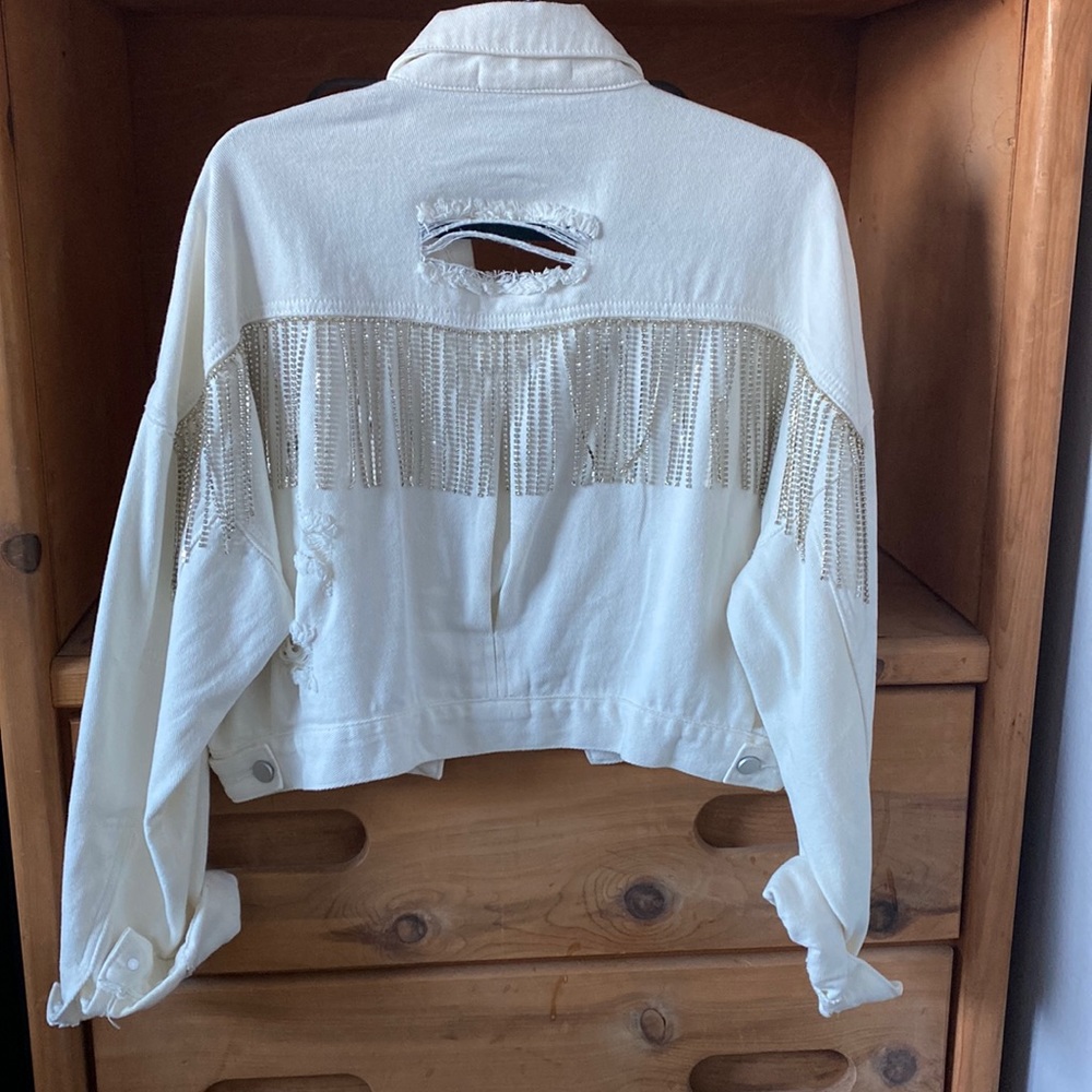 White distressed Jean jacket with rhinestone fringe across the back.